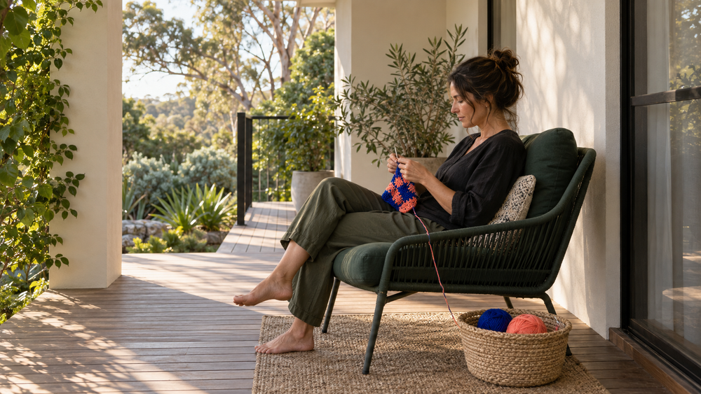 Adult crocheting with colourful yarn on an Australian verandah