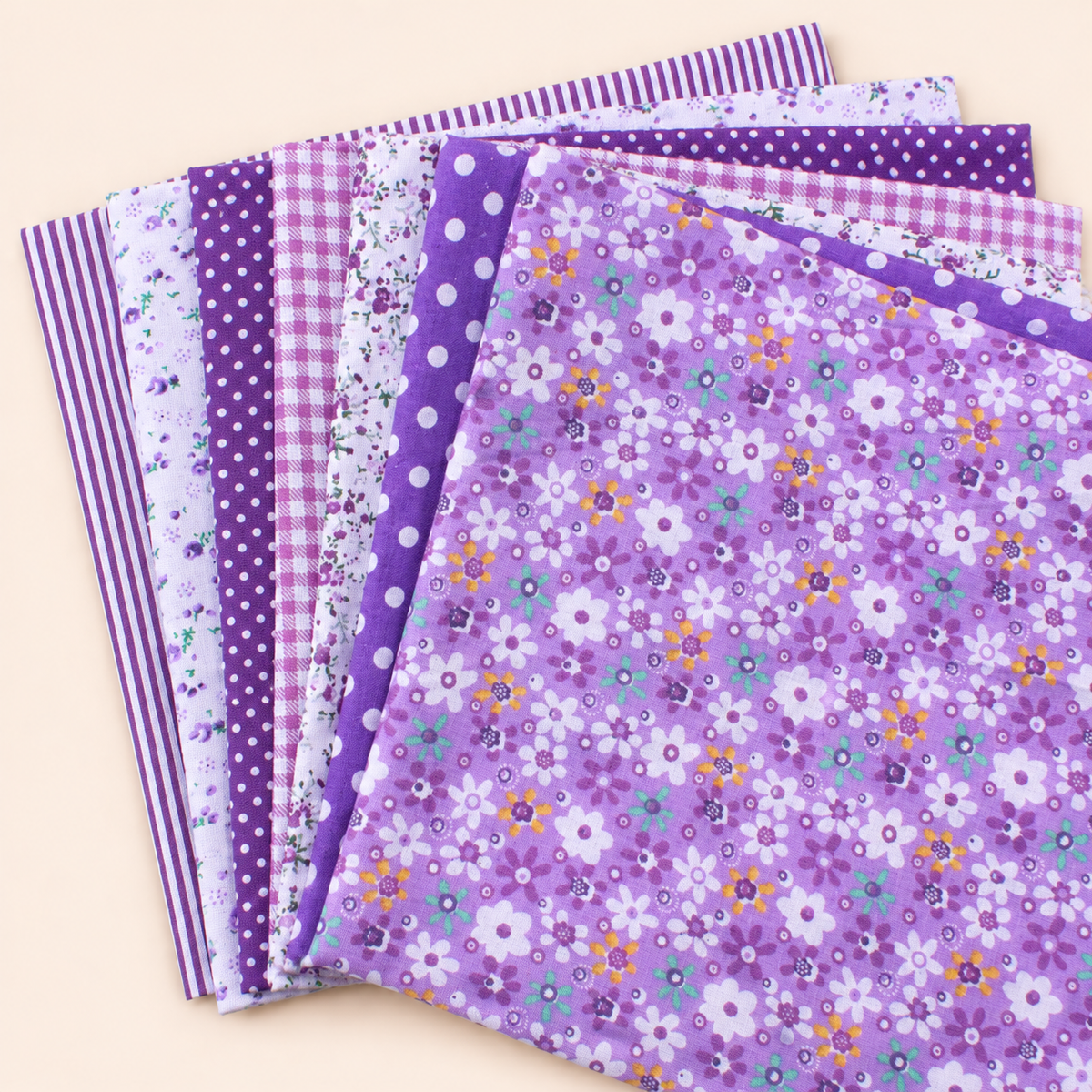 Purple cotton fabric bundle — seven 25 cm squares on cream
