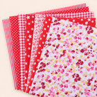 Red cotton fabric bundle — seven 25 cm squares on cream