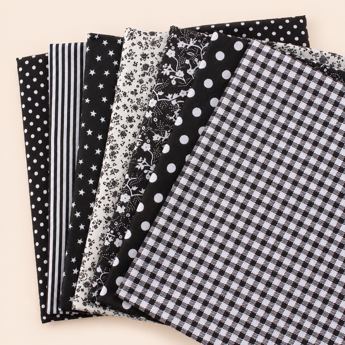 Black cotton fabric bundle — seven 25 cm squares on cream