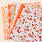 Orange cotton fabric bundle — seven 25 cm squares on cream