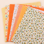 Orange 2 cotton fabric bundle — seven 25 cm squares on cream